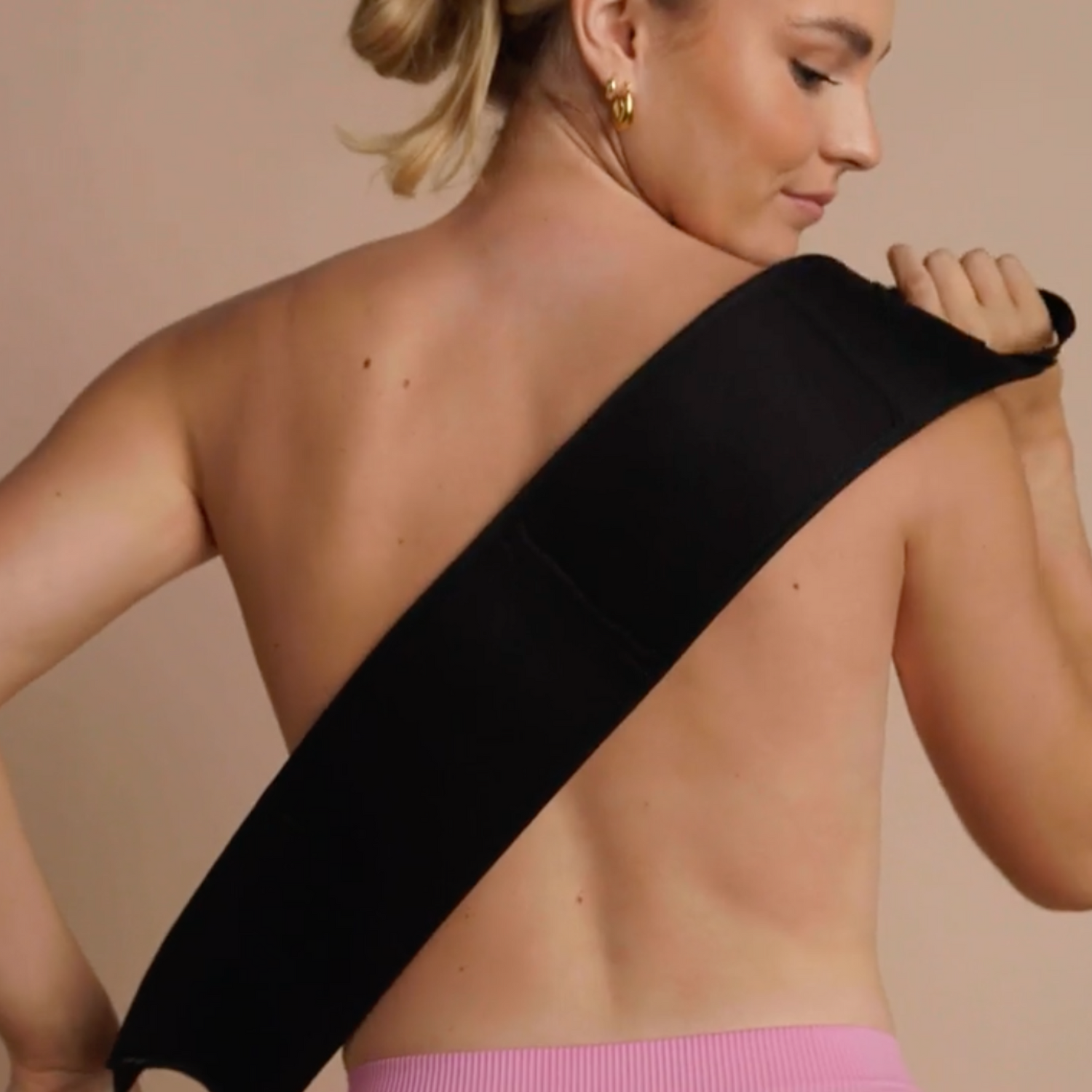 Model using Ohh My Glo self tan back applicator to reach hard-to-tan areas